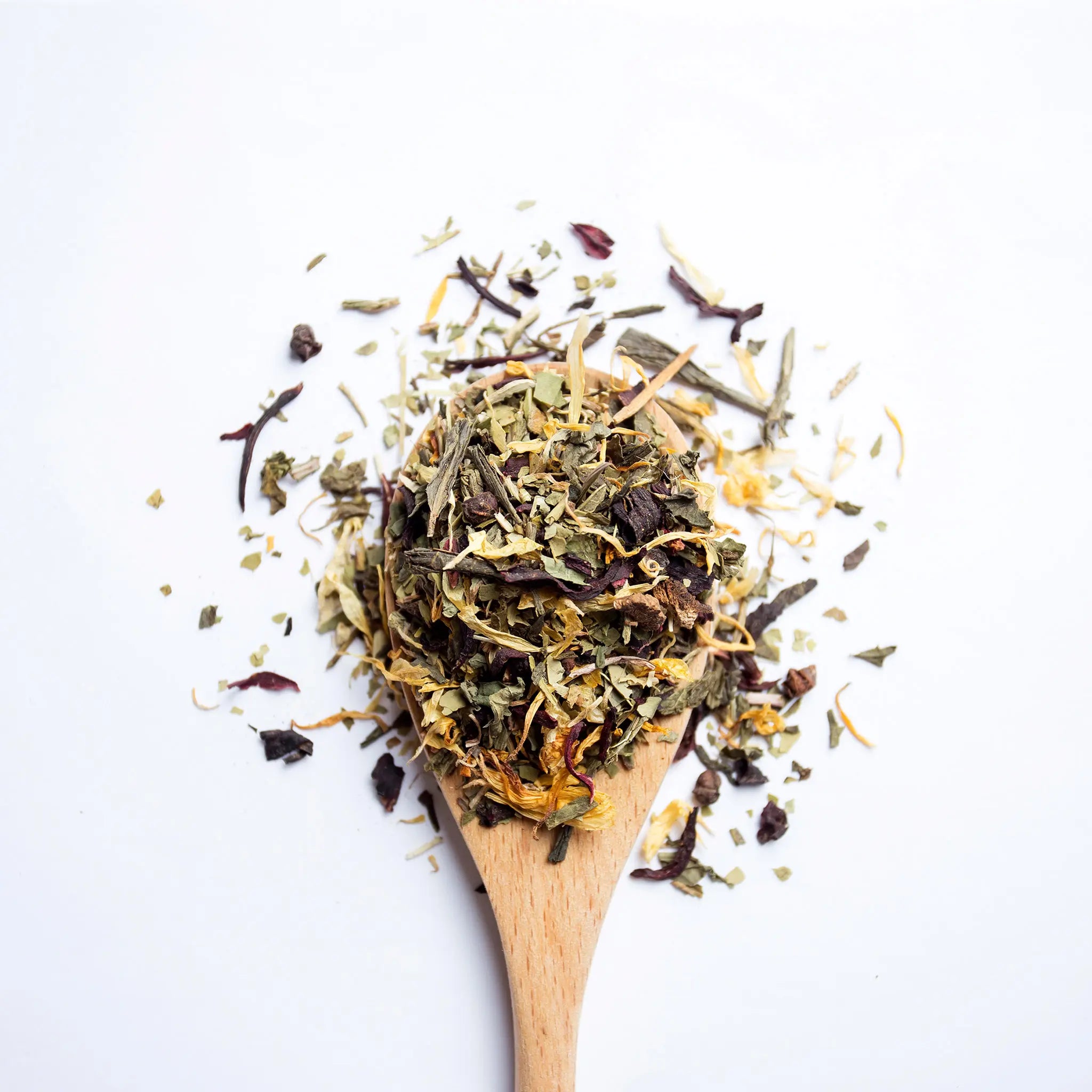 A wooden spoon with loose leaf tea